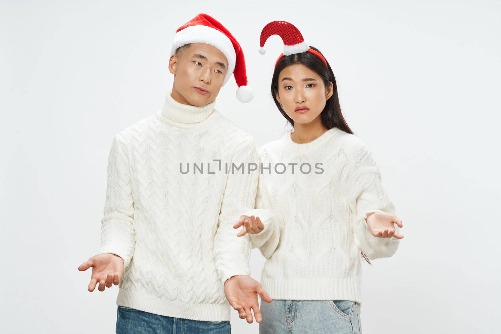 man and woman in holiday hats celebrate Christmas by SHOTPRIME