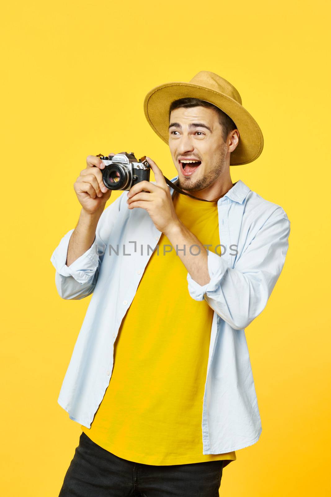 Happy photographer with a camera in his hands and looks away on an isolated background