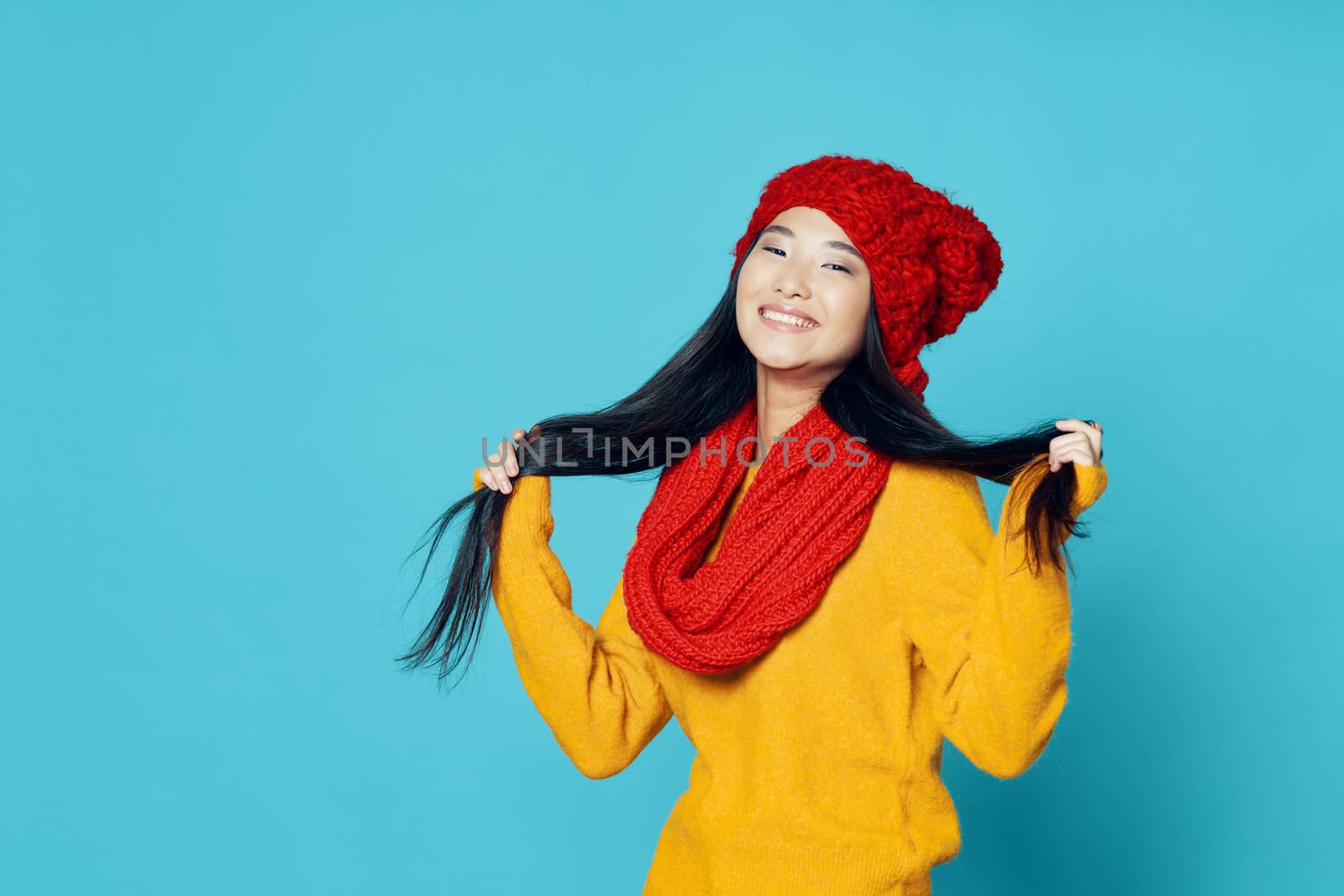 Happy woman touches her hair with her hands and laughs at the camera on an isolated background