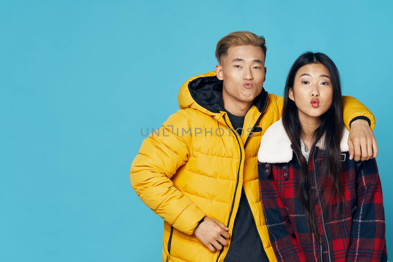 Man in a yellow jacket Asian appearance and woman air kiss love