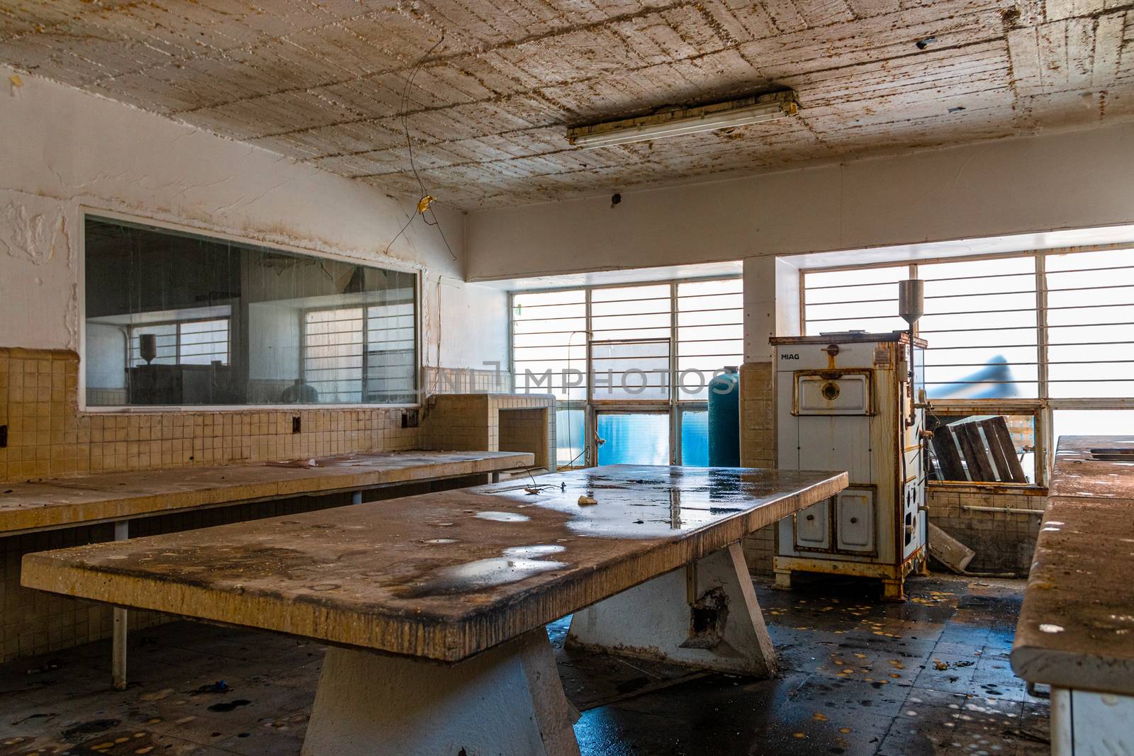 Chemistry laboratory in abandoned school with examination table in the center. backlighting