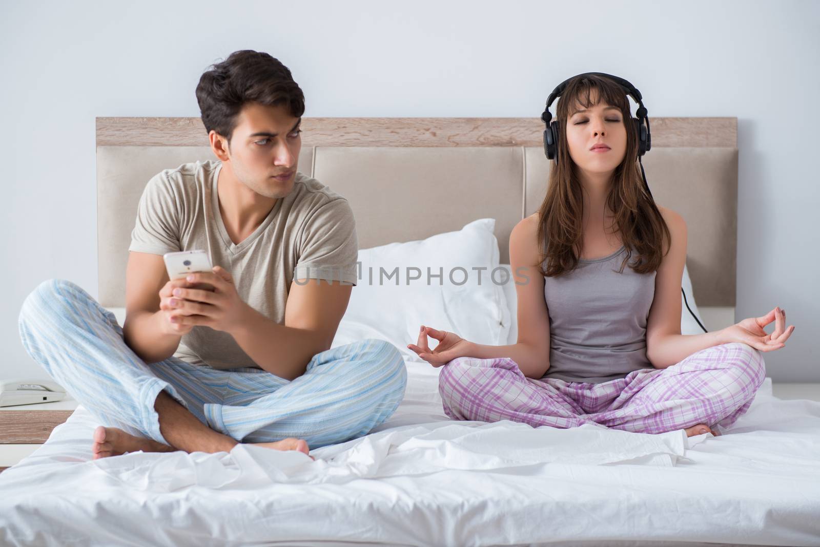 Young family meditating in the bed bedroom