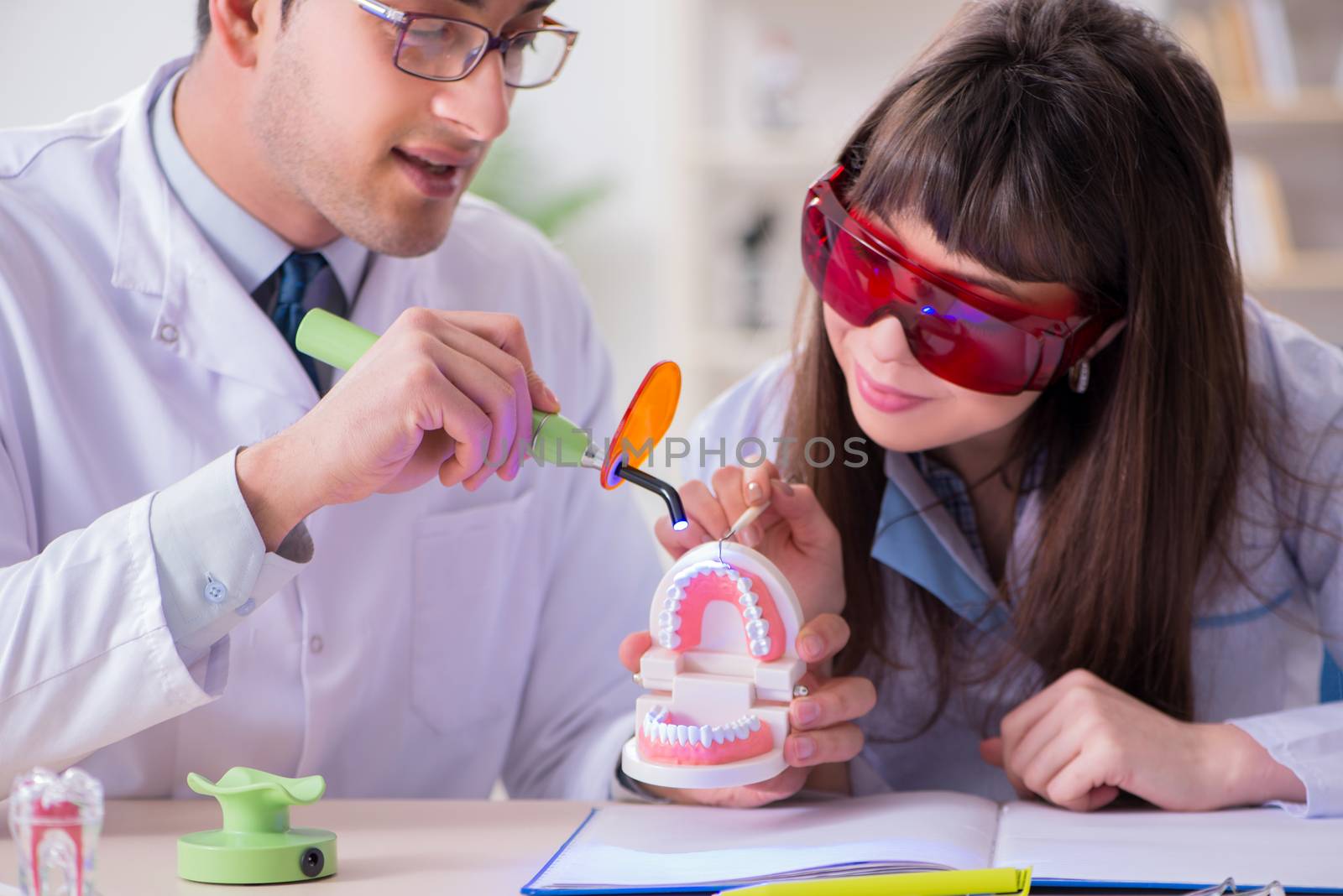 Doctor explaining to assistant how to use ultraviolet gun