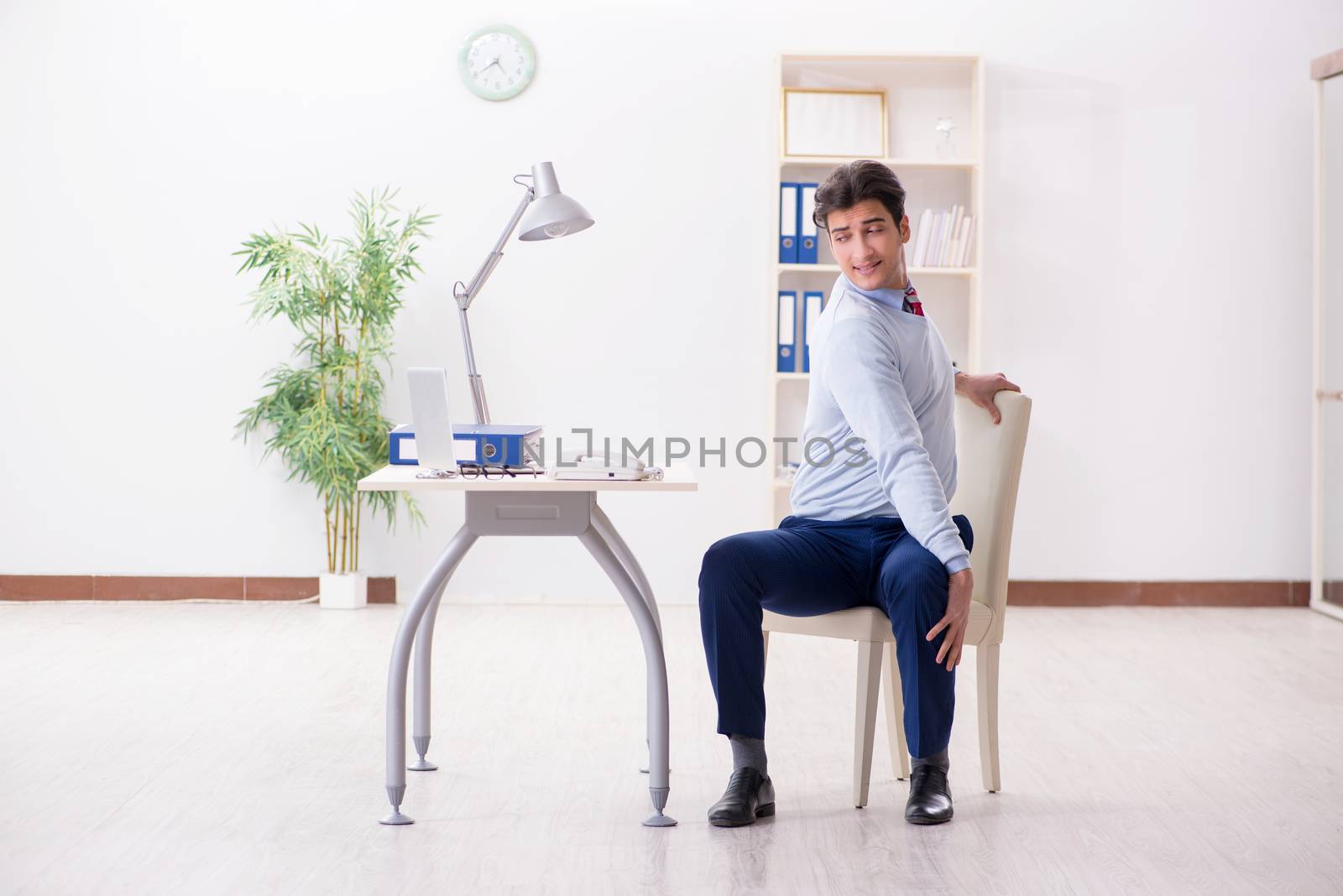 Employee doing stretching exercises in the office by Elnur