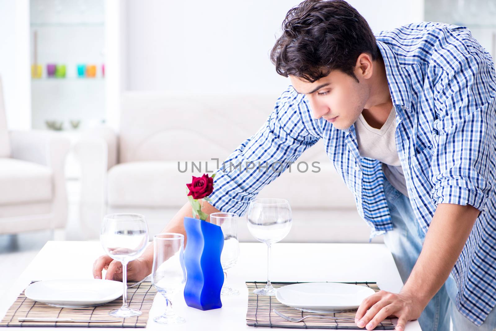 Man alone preparing for romantic date with his sweetheart by Elnur