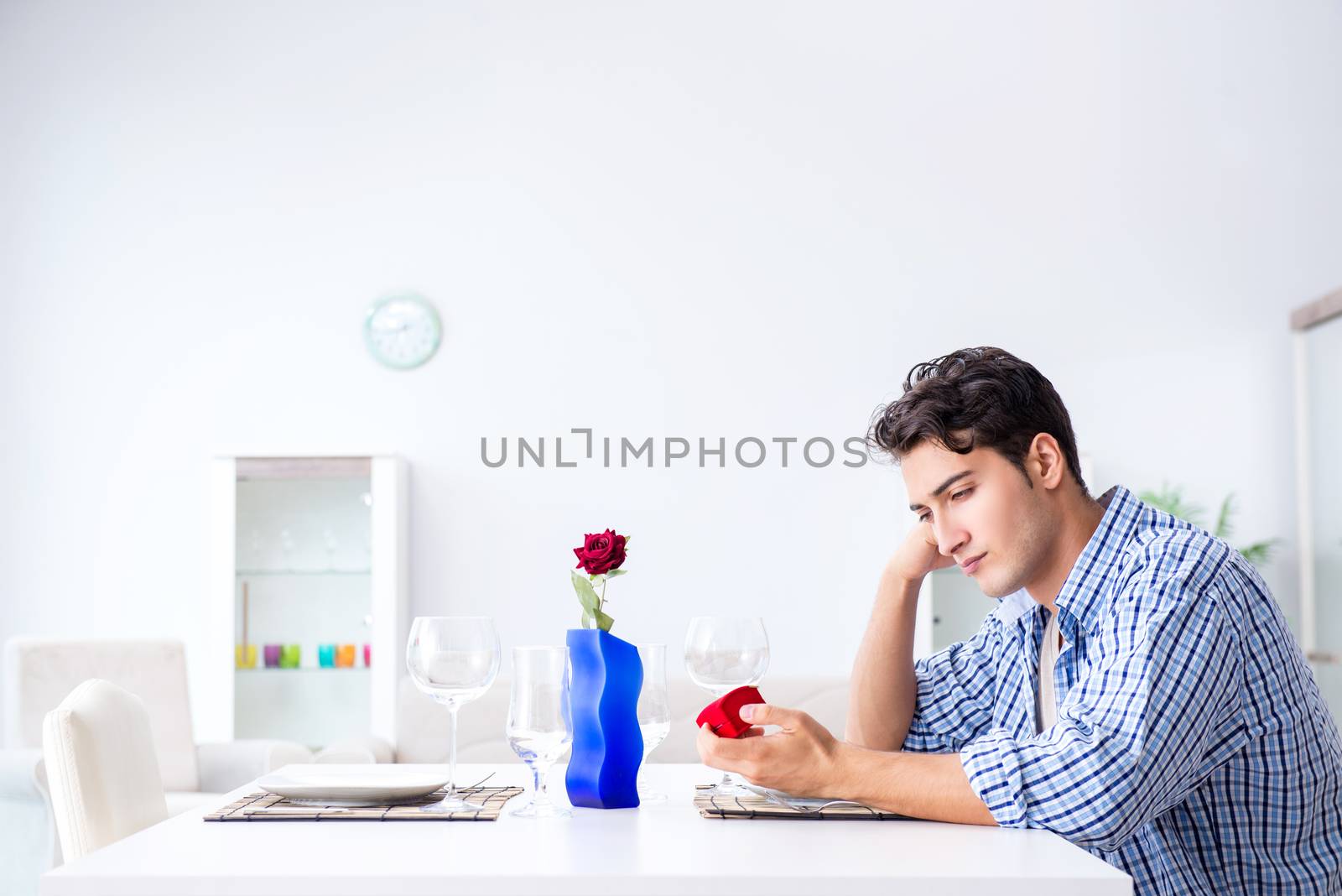 Man alone preparing for romantic date with his sweetheart by Elnur
