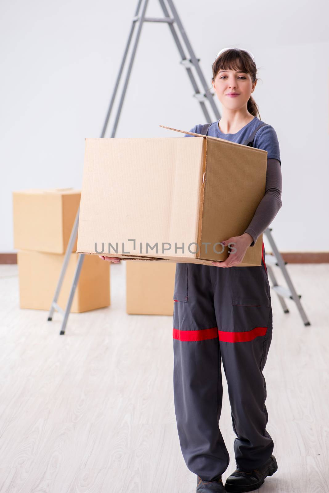 Woman contractor moving boxes in relocation concept
