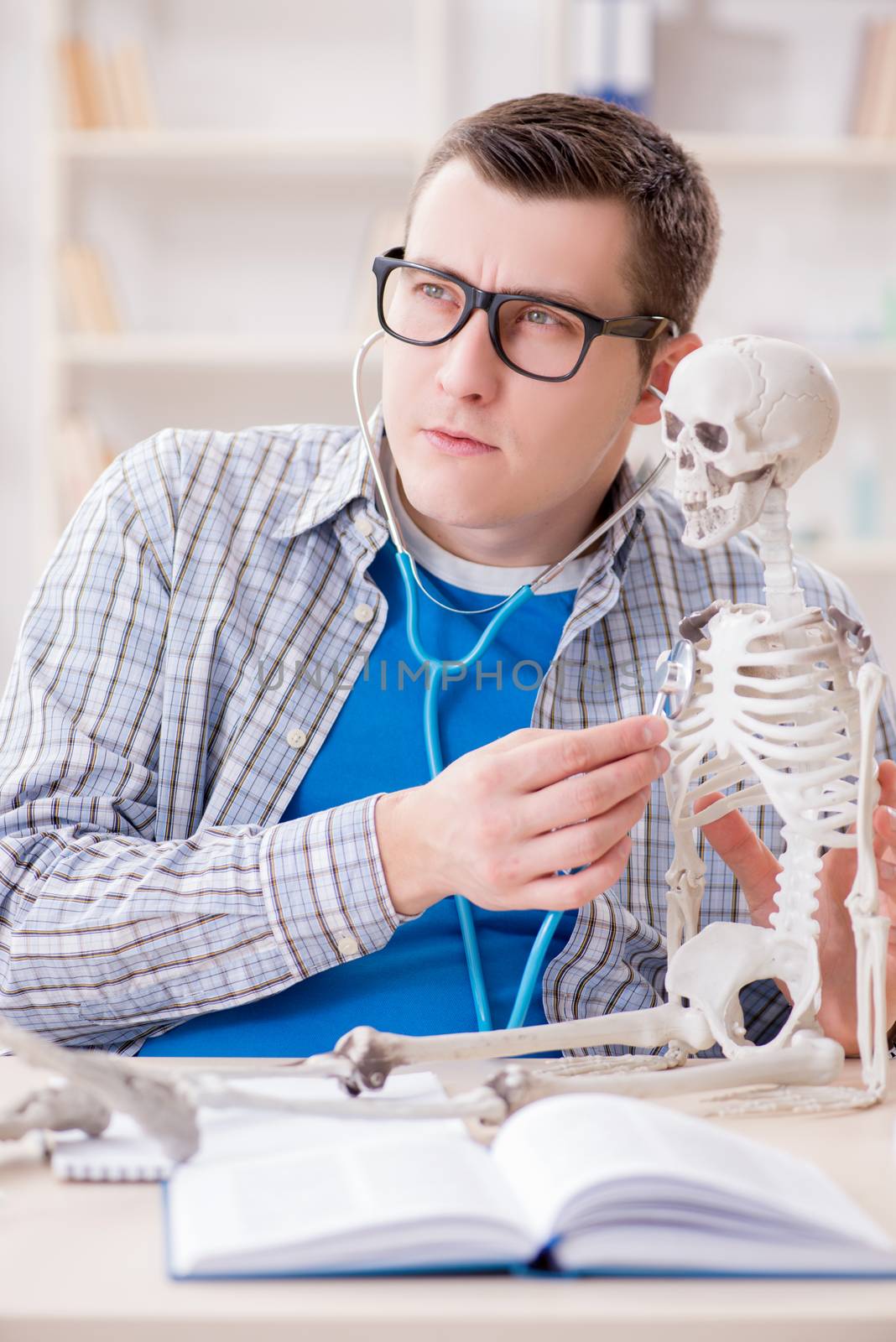 Medical student studying skeleton in classroom during lecture