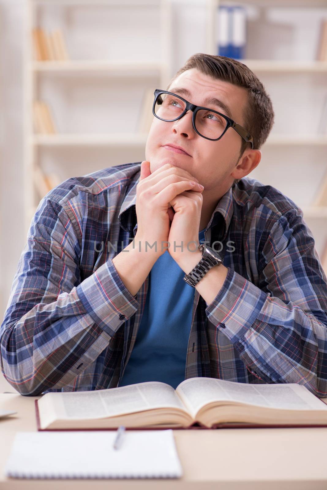 Young student preparing to school exams with books