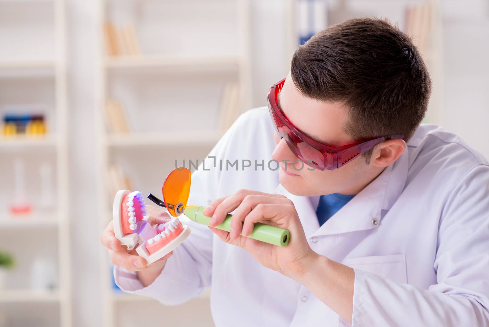 Dentist working teeth implant in medical lab by Elnur