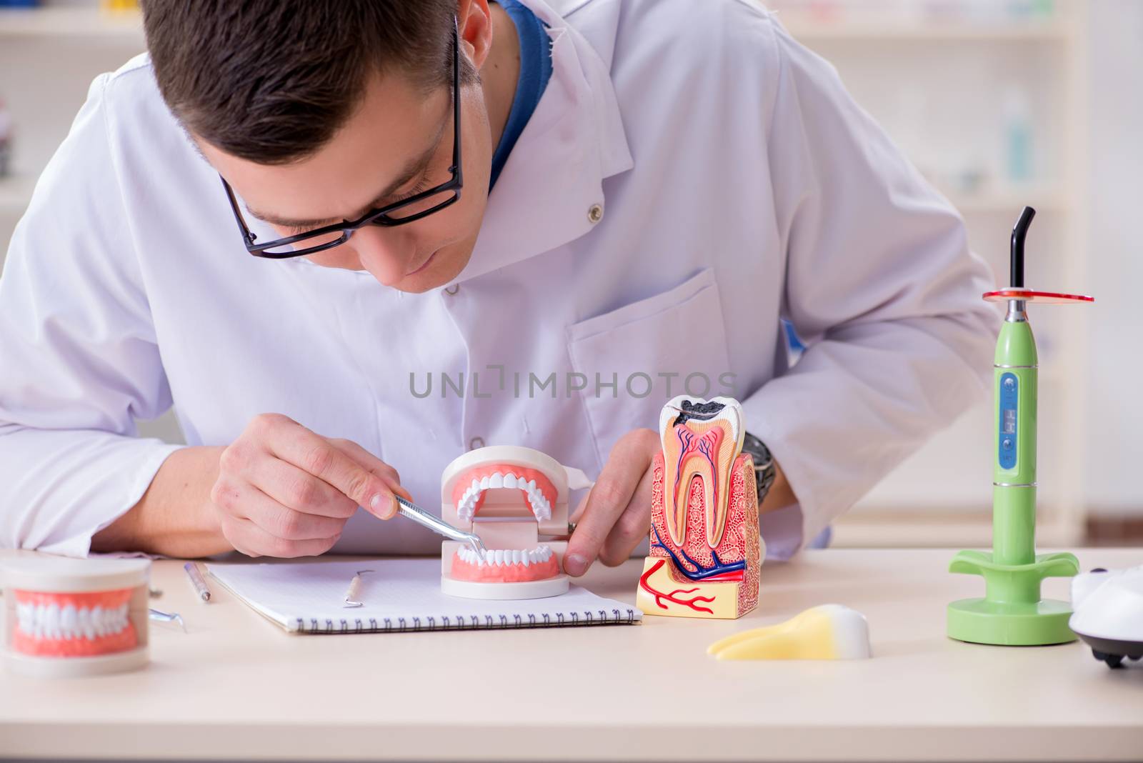 Dentist working teeth implant in medical lab by Elnur
