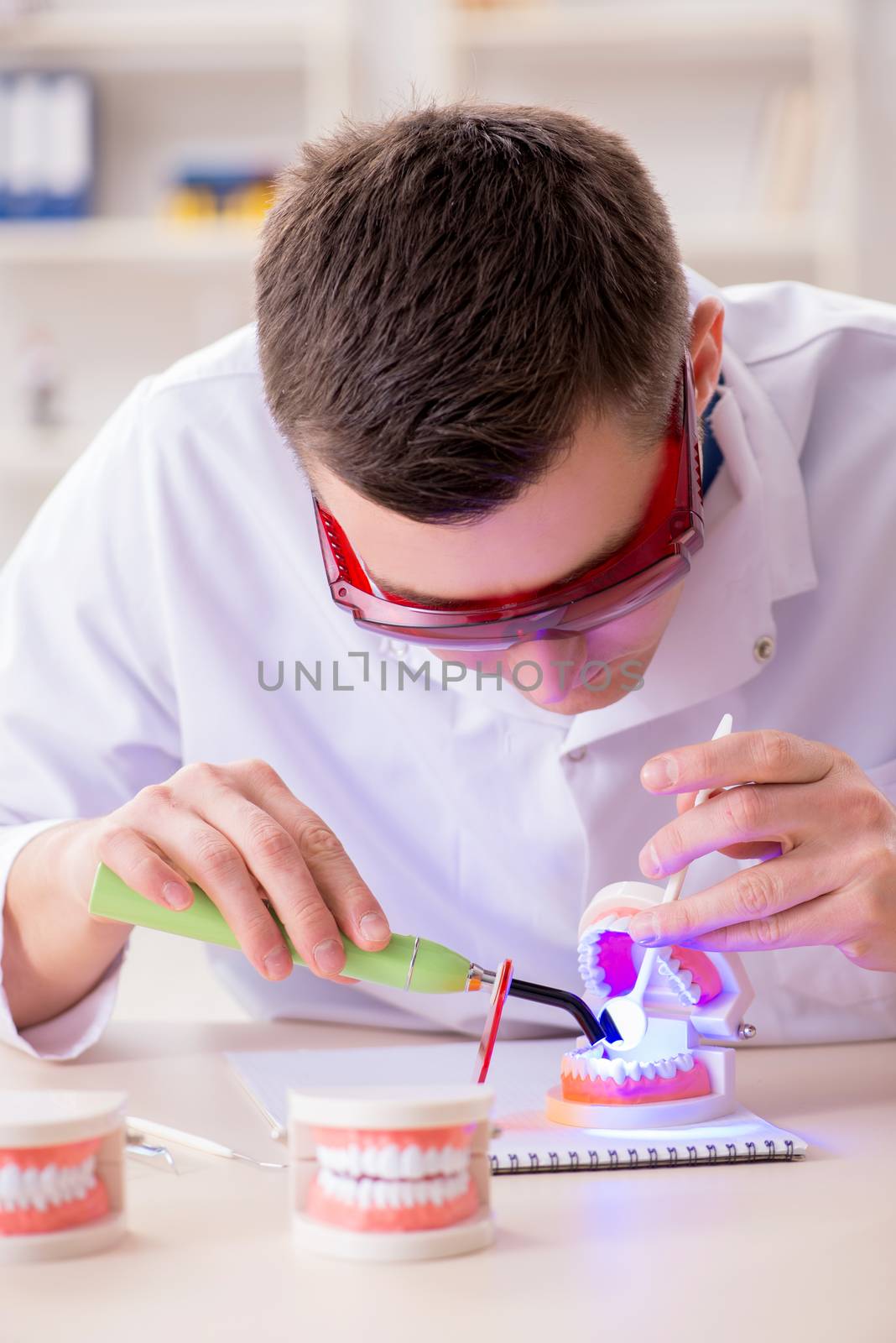 Dentist working teeth implant in medical lab