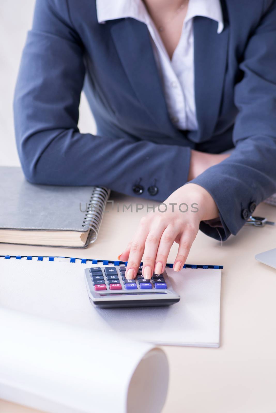 Female finance professional working on keyboard with reports