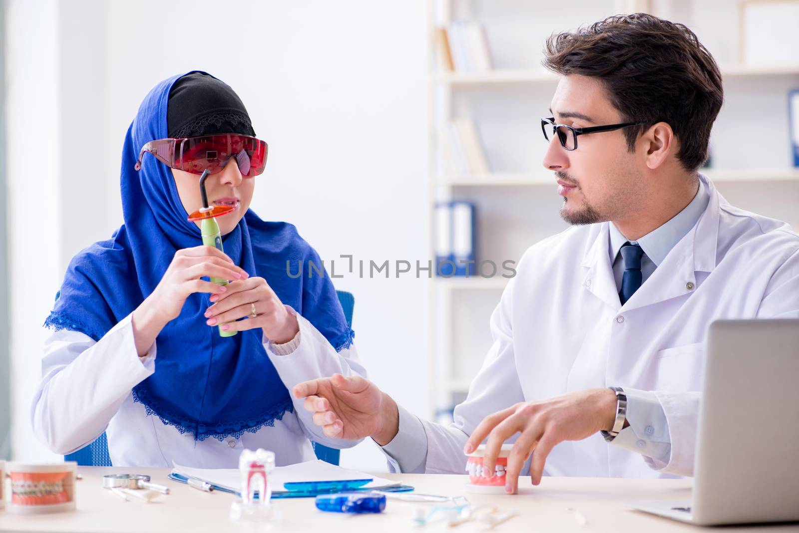 Dentist doctor and assistant working on new tooth implant by Elnur