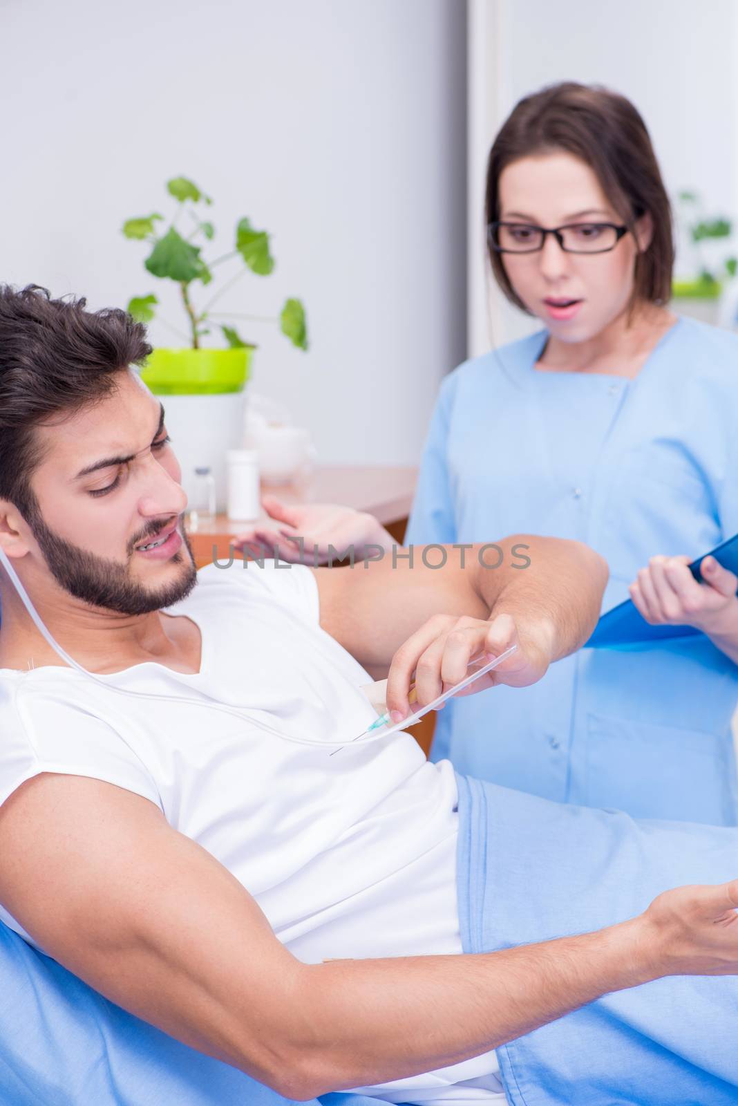 Woman doctor examining male patient in hospital
