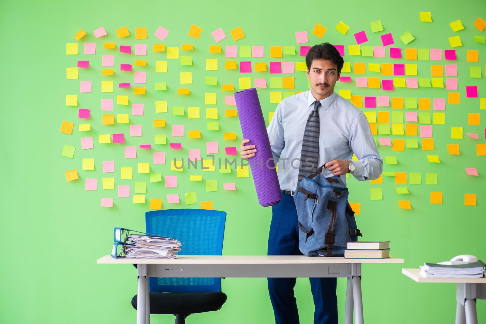 Man in the office with many conflicting priorities preparing go for training
