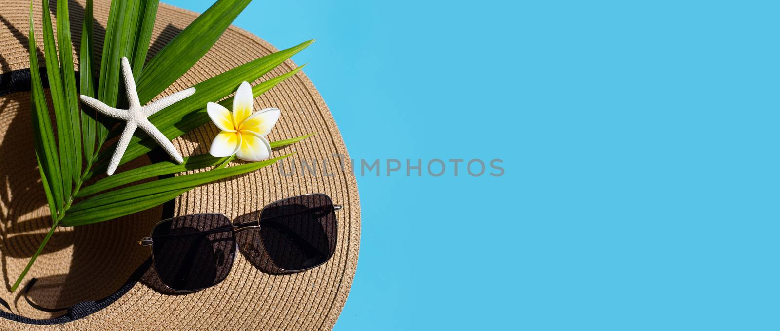 Summer hat with sunglasses on blue background. Enjoy holiday con by Bowonpat