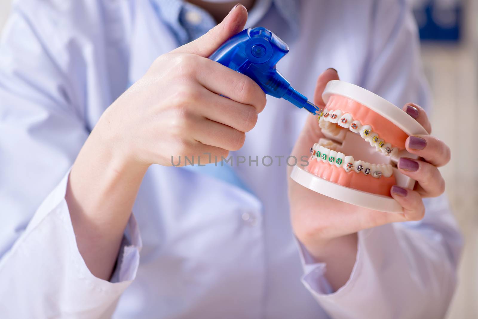 Woman dentist practicing work on tooth model