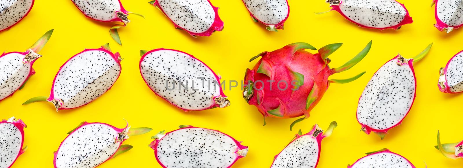 Ripe dragonfruit or pitahaya slices on yellow background. Top view