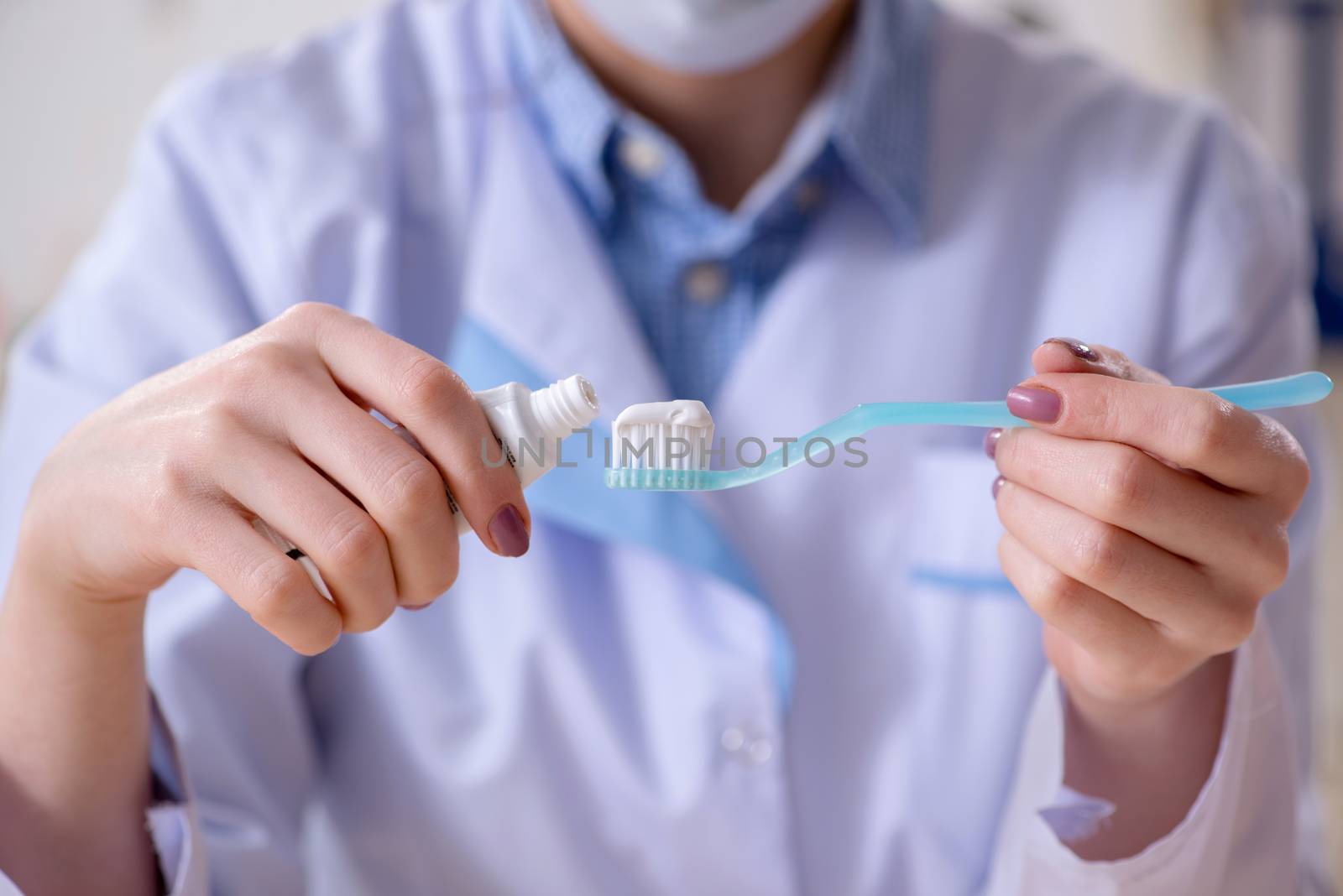 Woman dentist practicing work on tooth model by Elnur