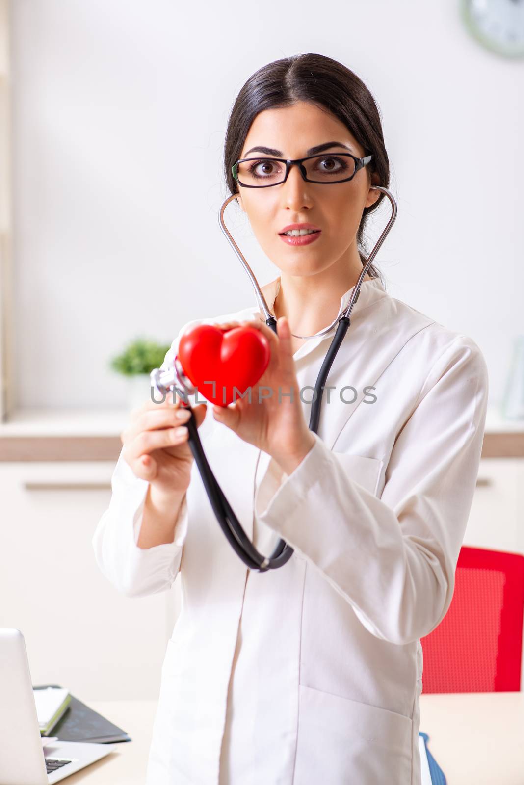 Young doctor in heart care concept by Elnur