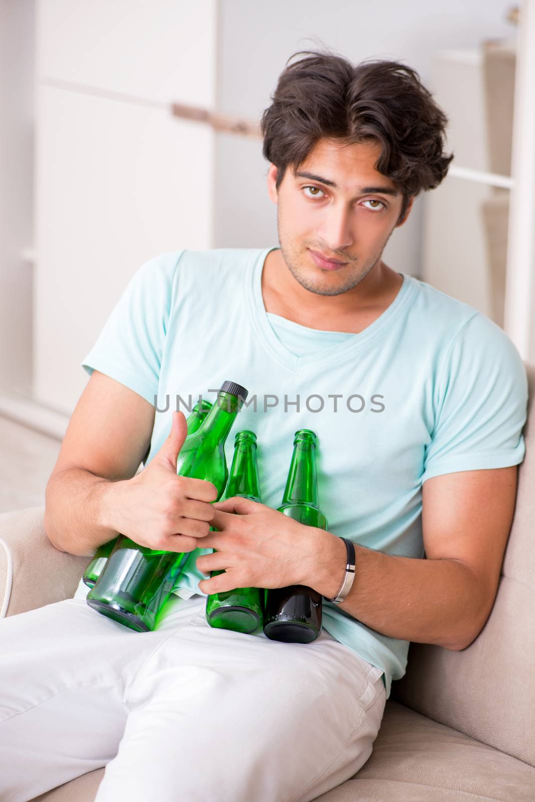 Young drunk handsome man after party at home 