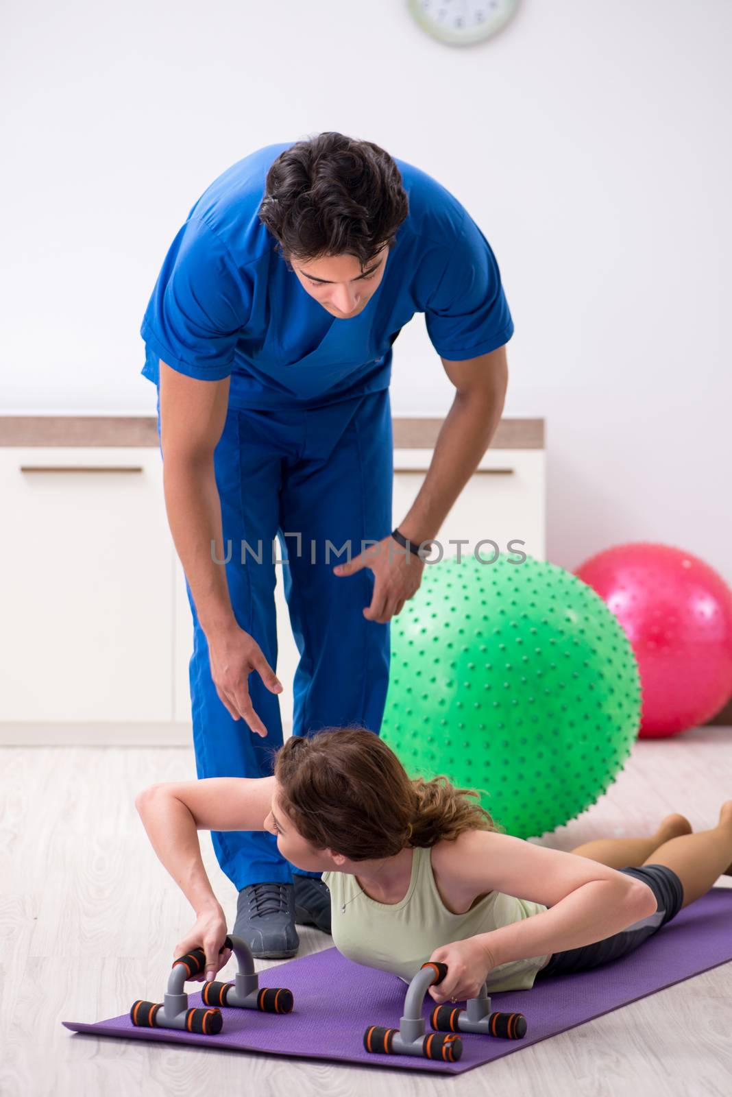 Fitness instructor helping sportsman during exercise