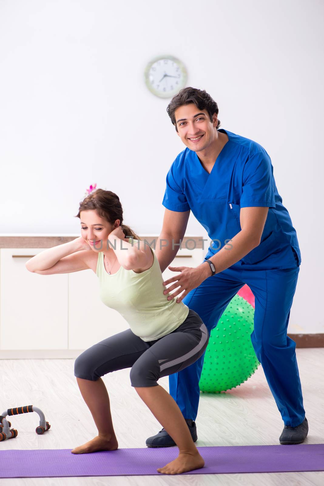 Fitness instructor helping sportsman during exercise