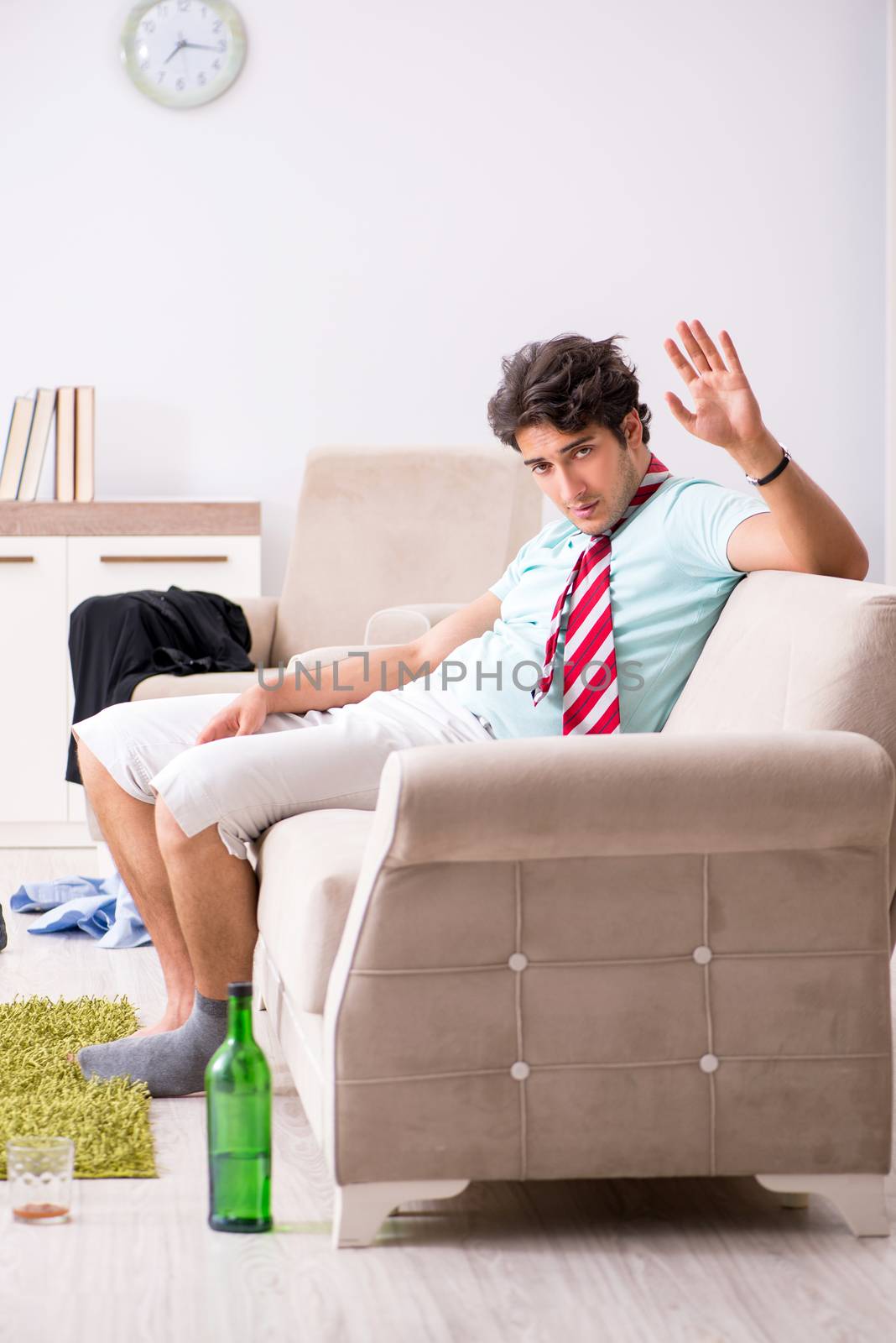 Young drunk handsome man after party at home 