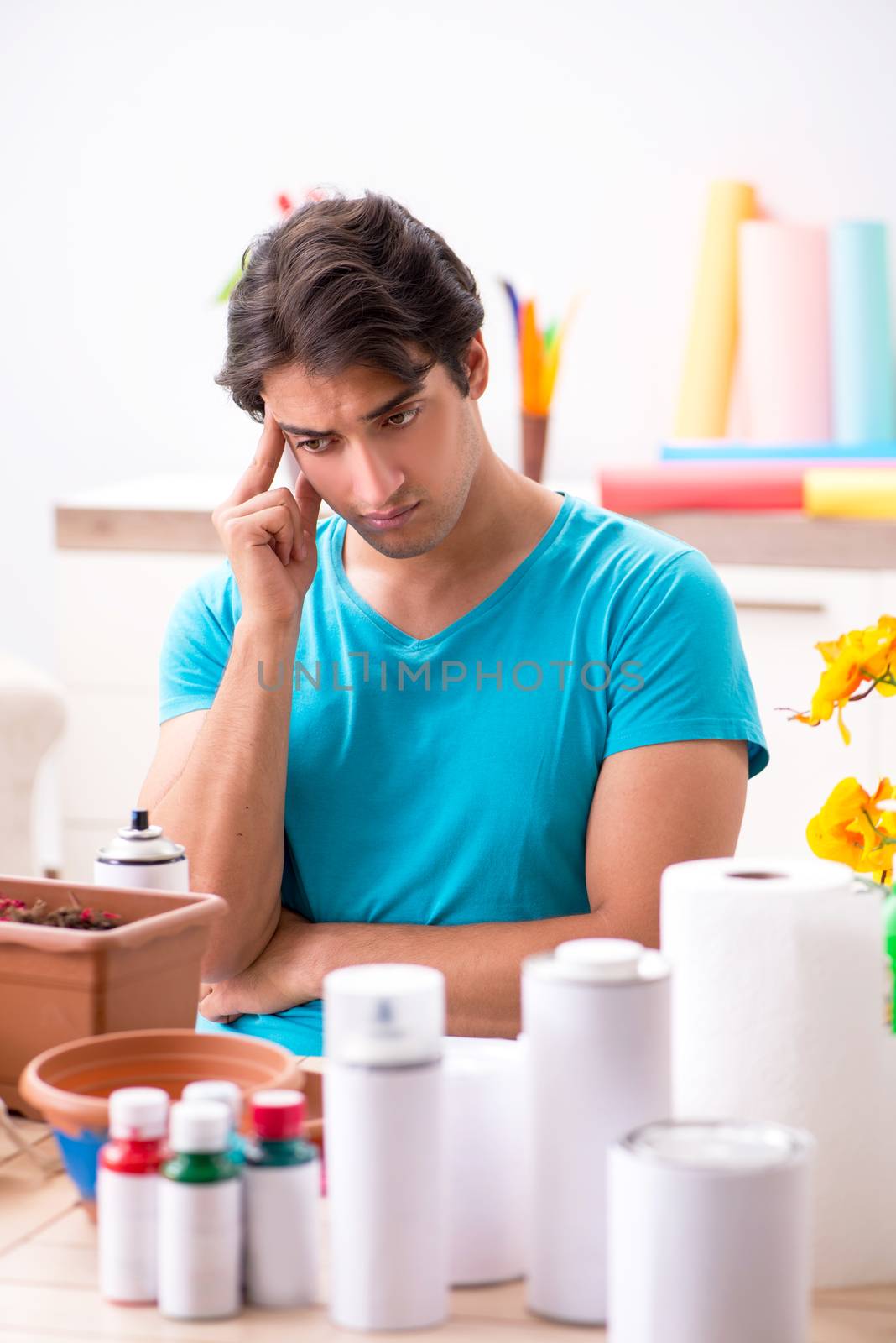 Young man decorating pottery in class
