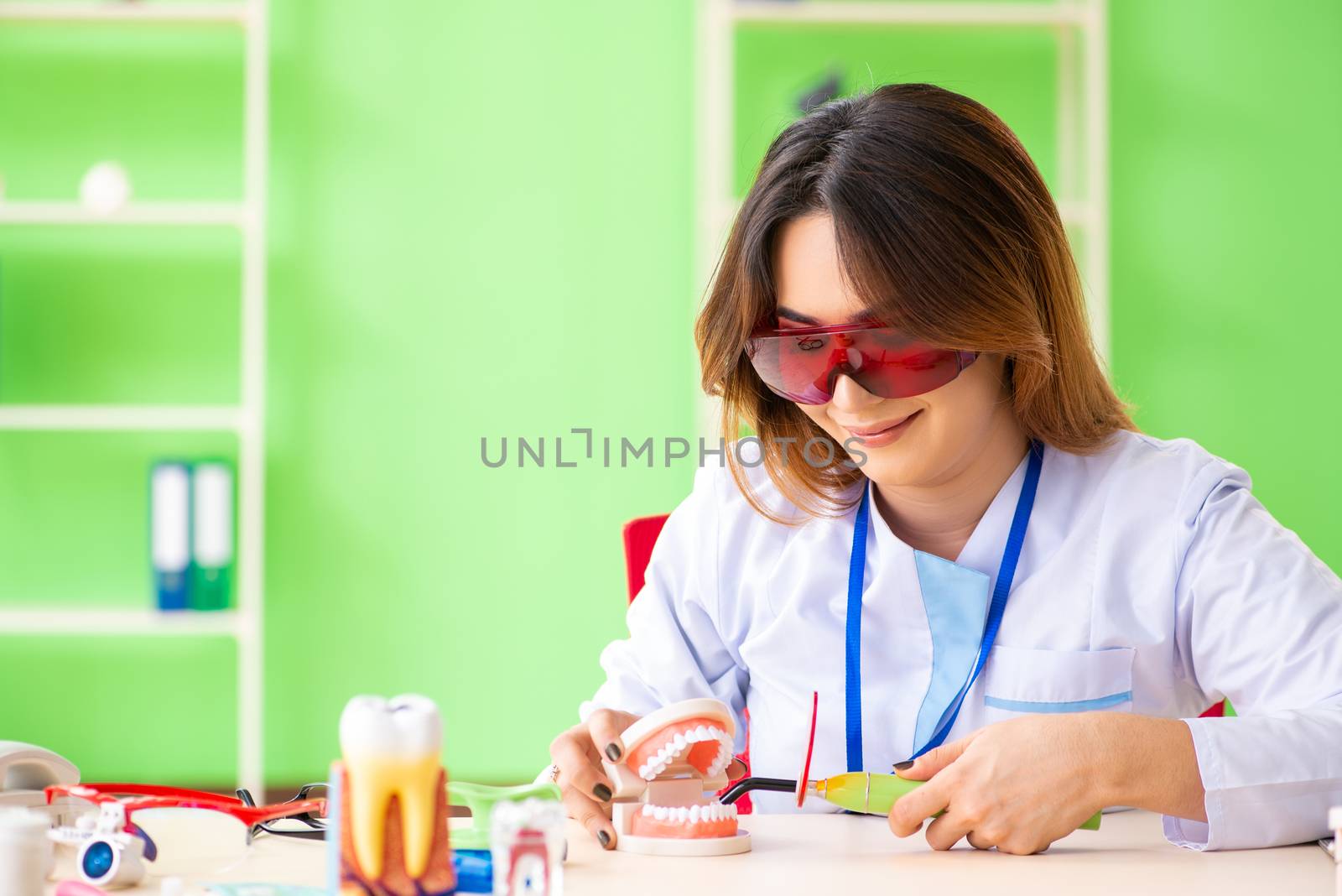 Woman dentist working on teeth implant by Elnur