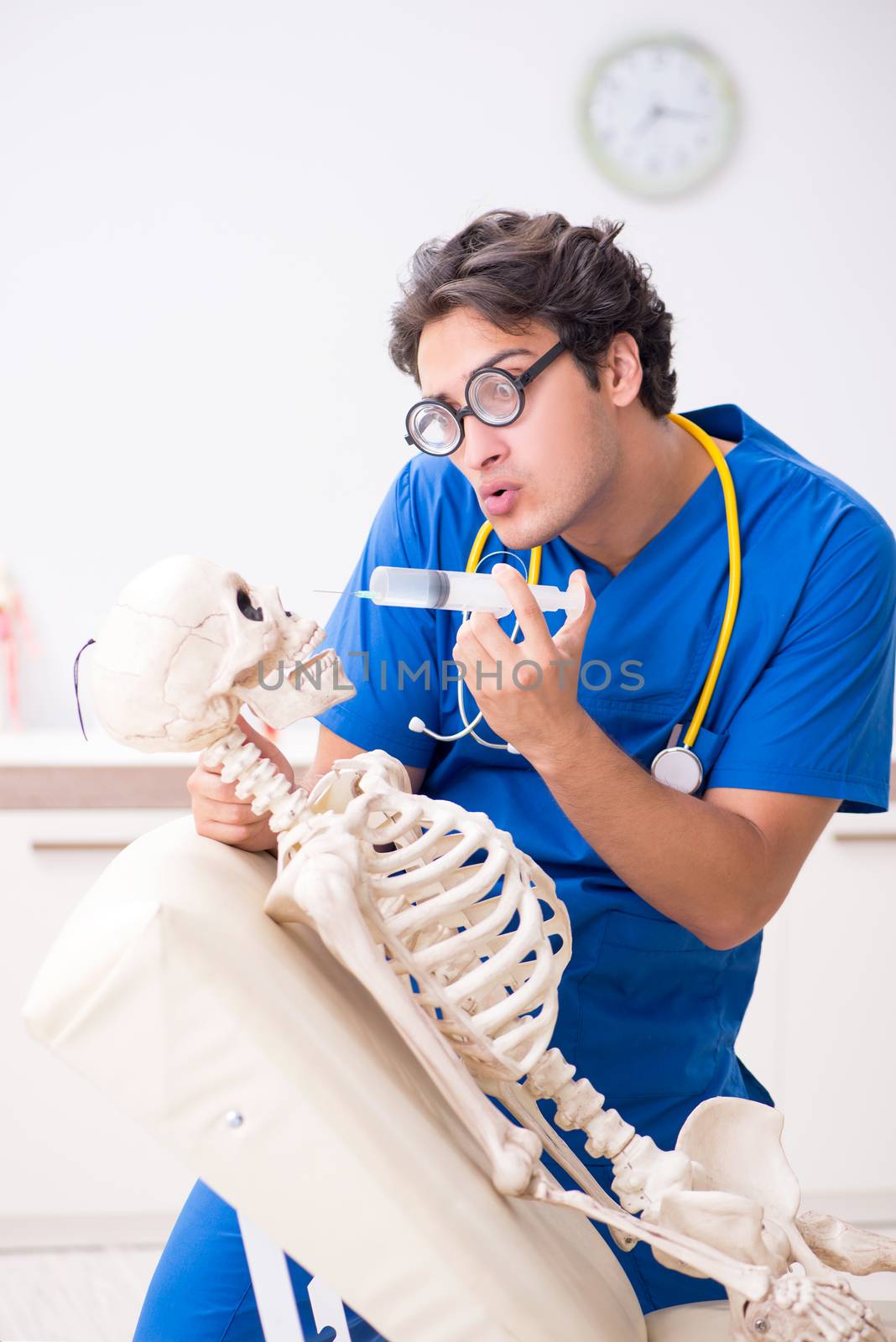 Funny doctor with skeleton in hospital