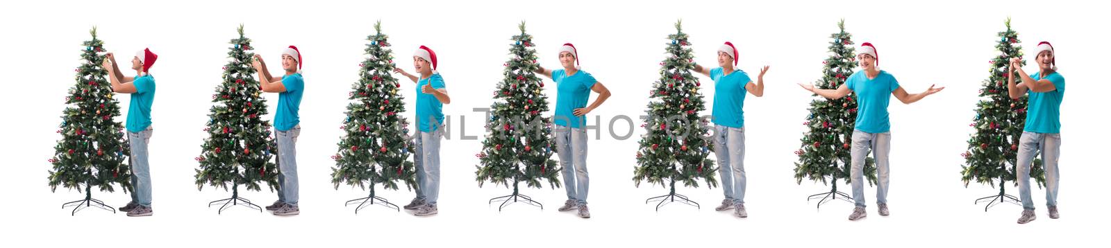 Young man decorating christmas tree isolated on white by Elnur