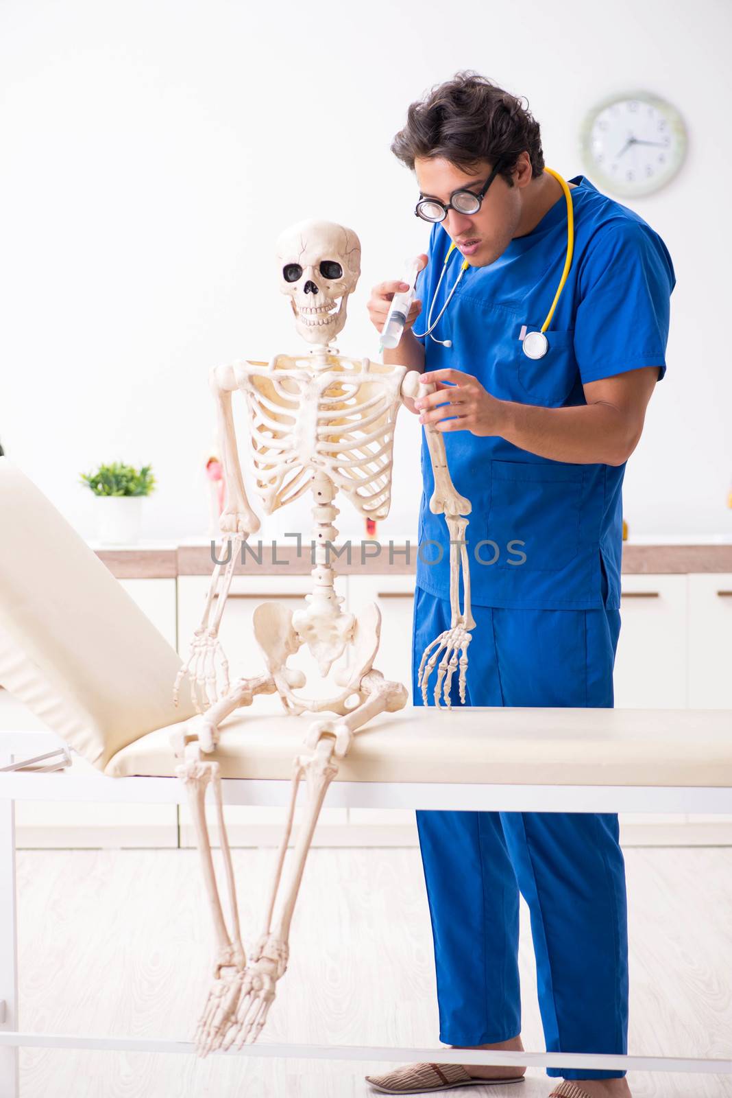 Funny doctor with skeleton in hospital