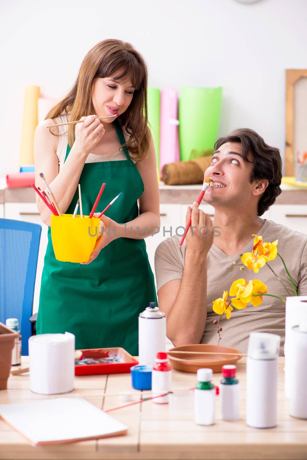 Couple decorating pots in workshop during class