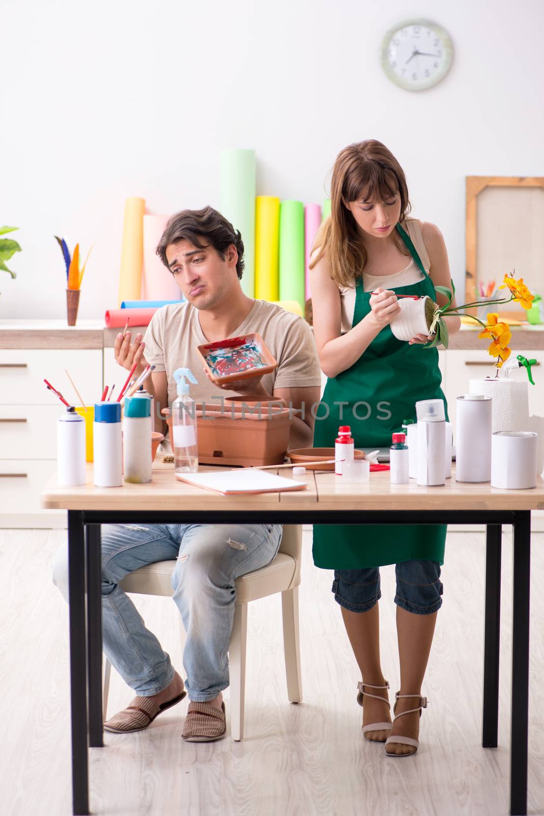 Couple decorating pots in workshop during class