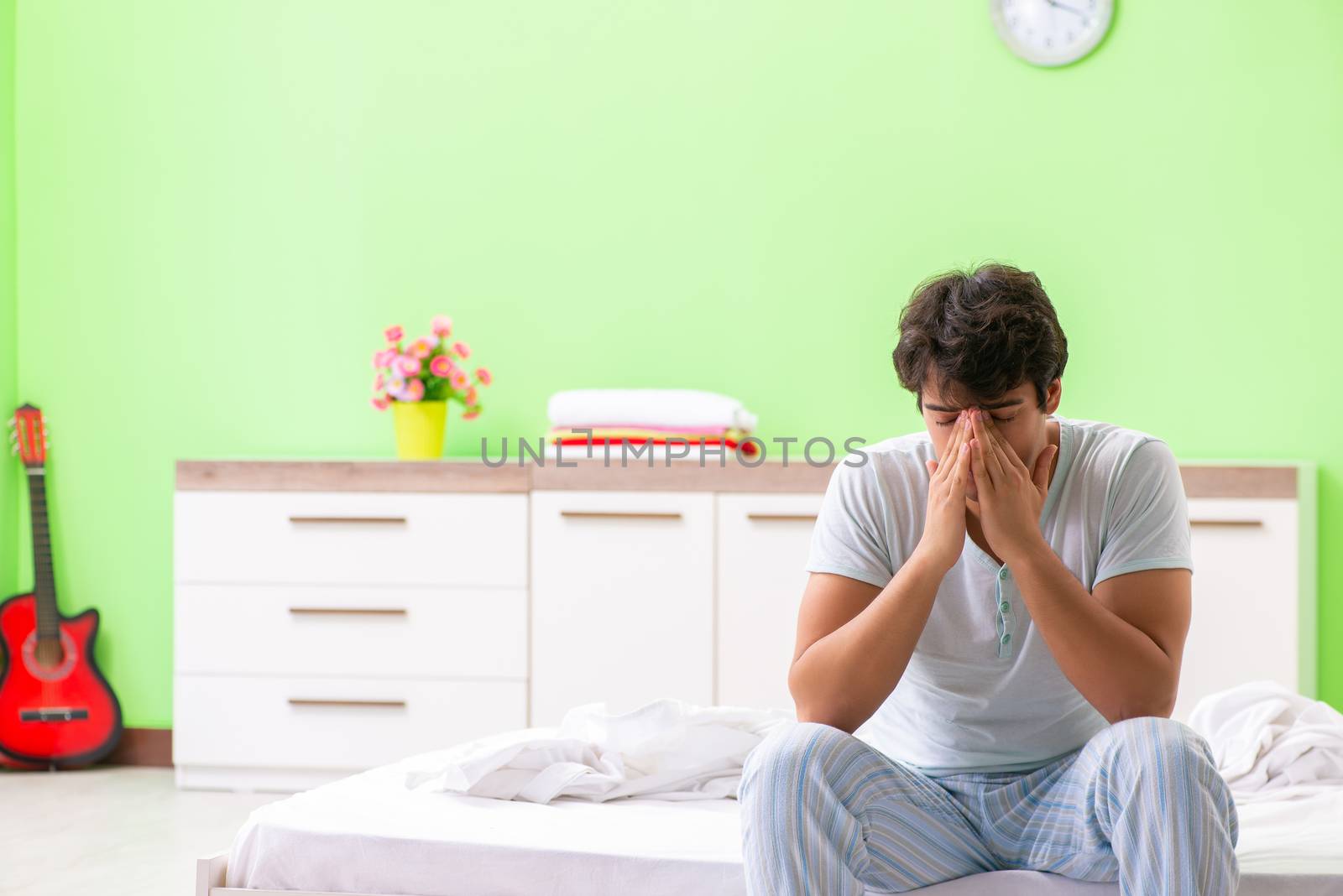 Young man having trouble waking up in early morning