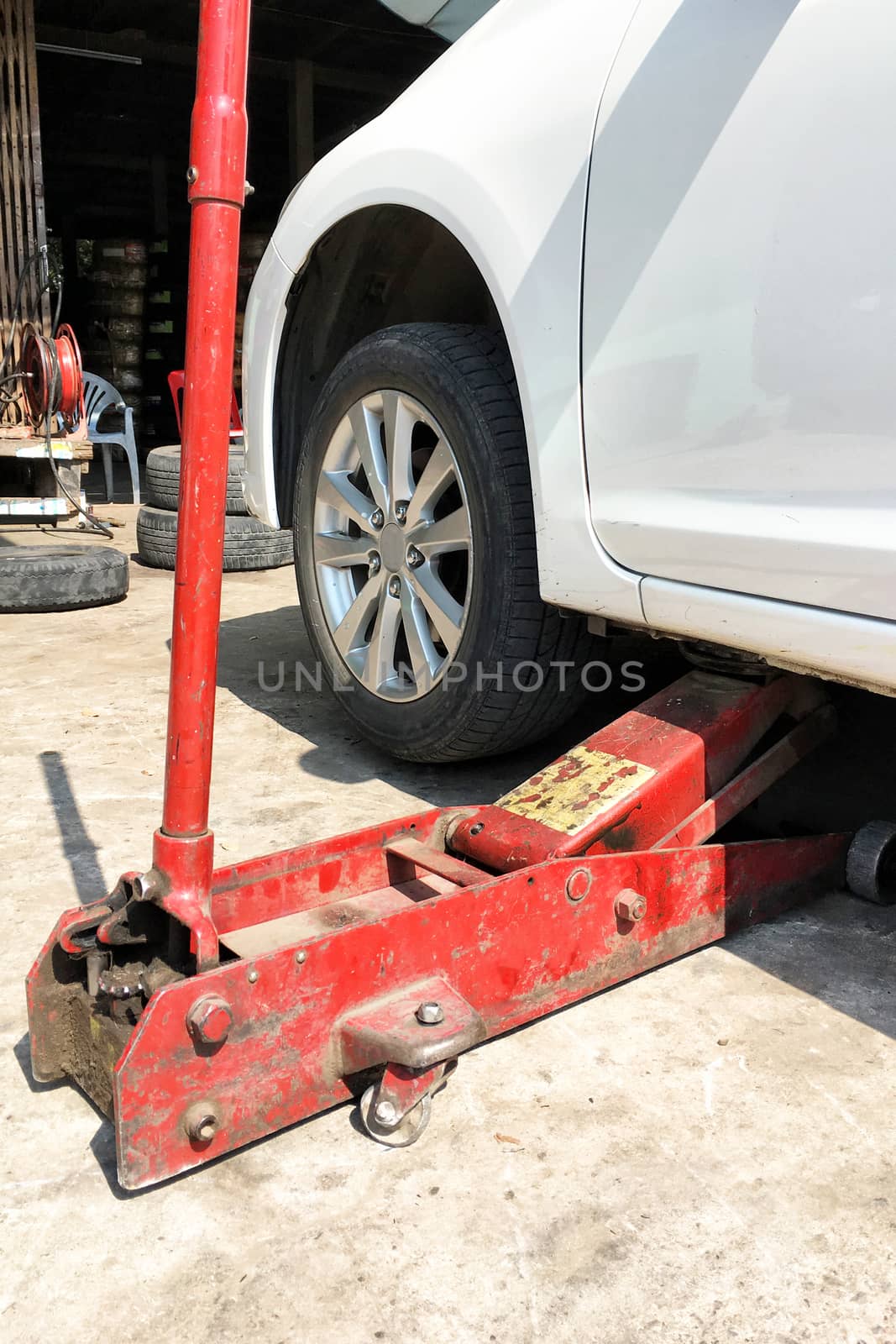 Changing car tire with hand jack by Surasak