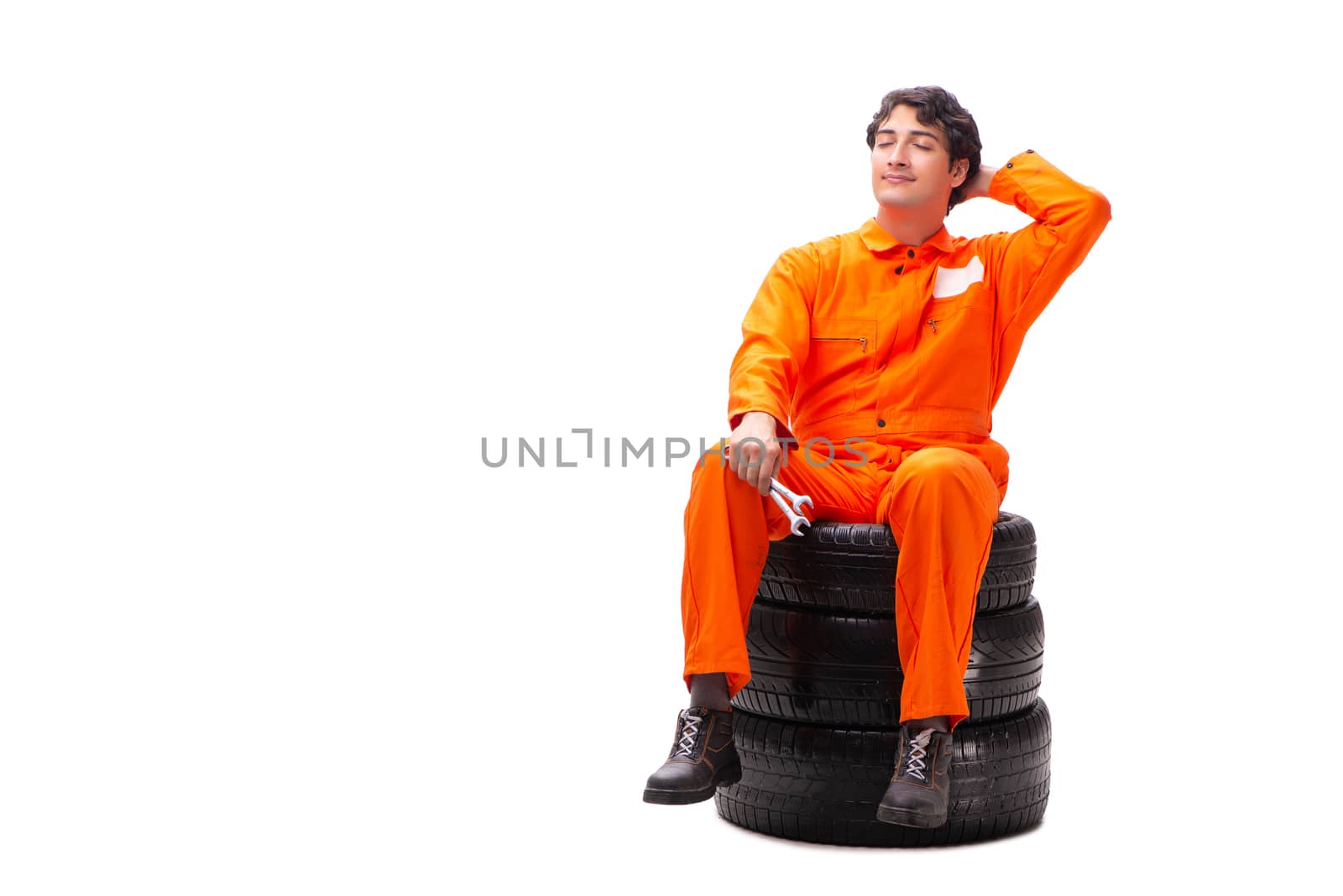 Young garage worker with tyre isolated on white