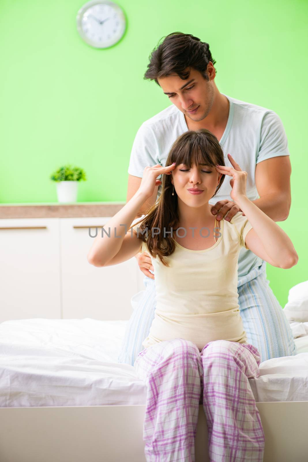 Man doing massage to his wife in bedroom 