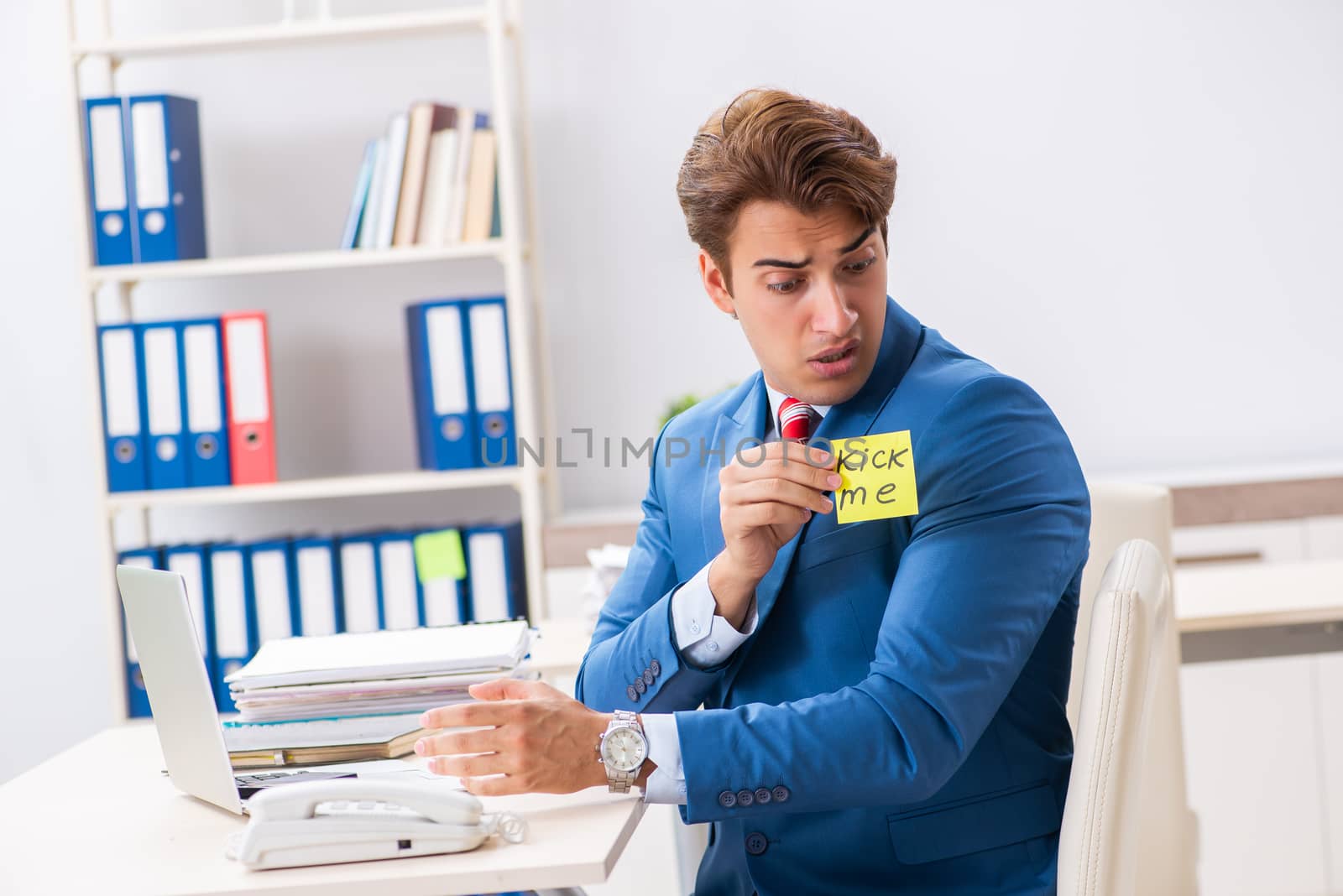 Office prank with kick me message on sticky note