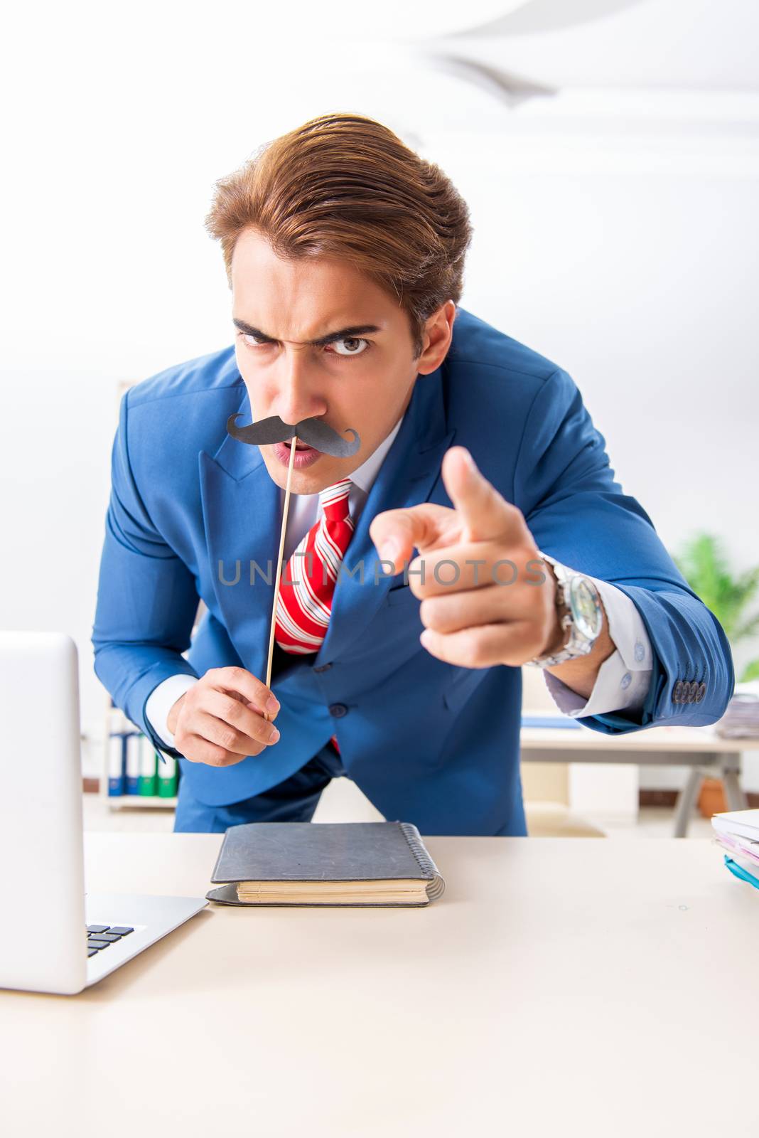 Funny bisinessman with fake moustache in the office