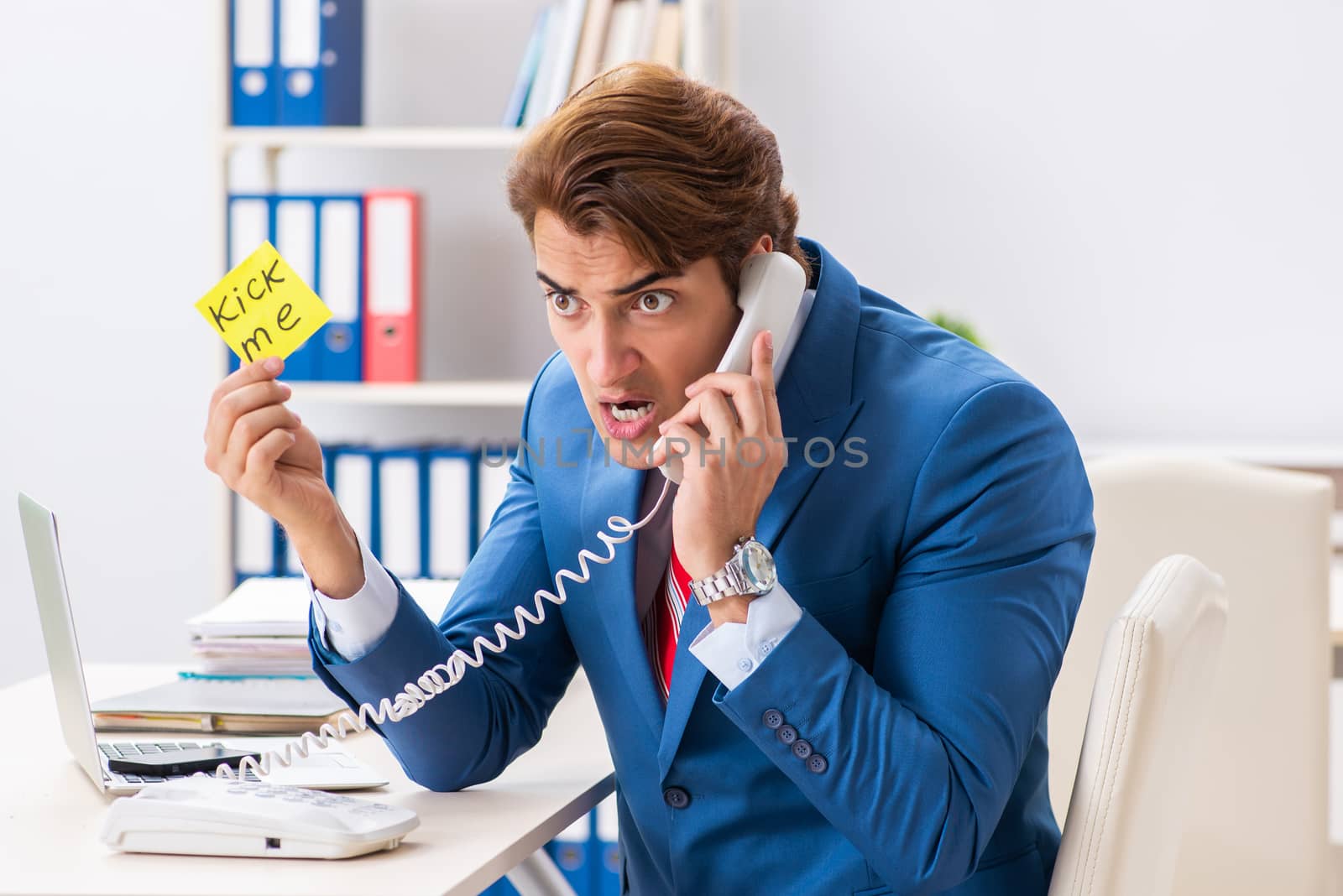 Office prank with kick me message on sticky note