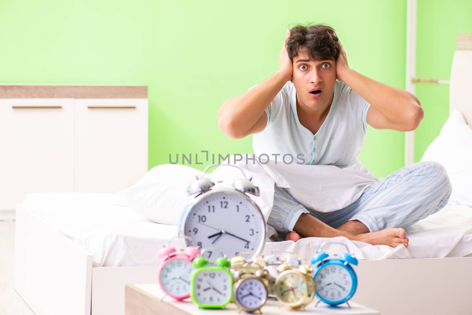 Young man having trouble waking up in early morning