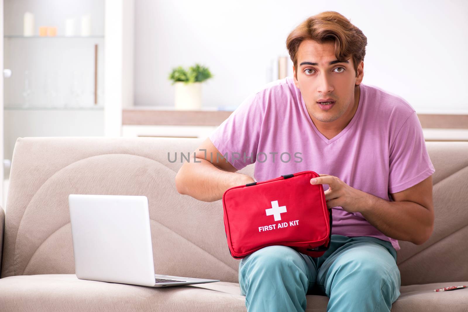 Sick man at home with first aid kit