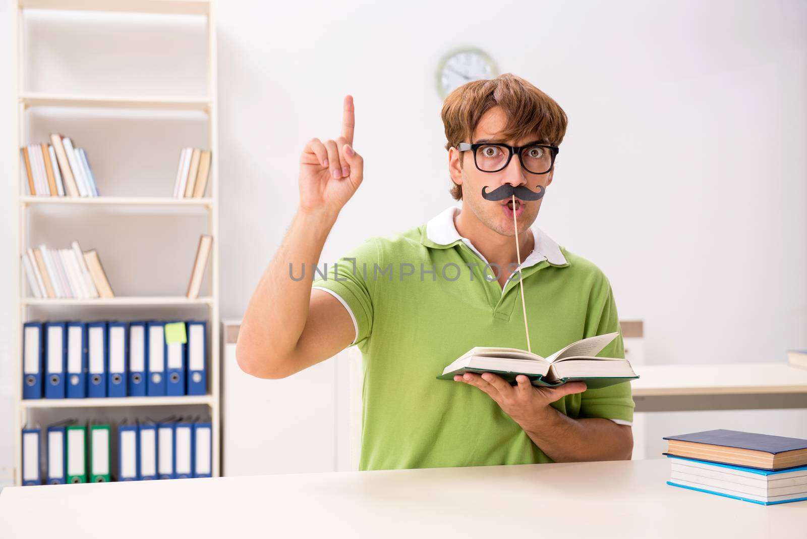 Student with fake moustache reading book