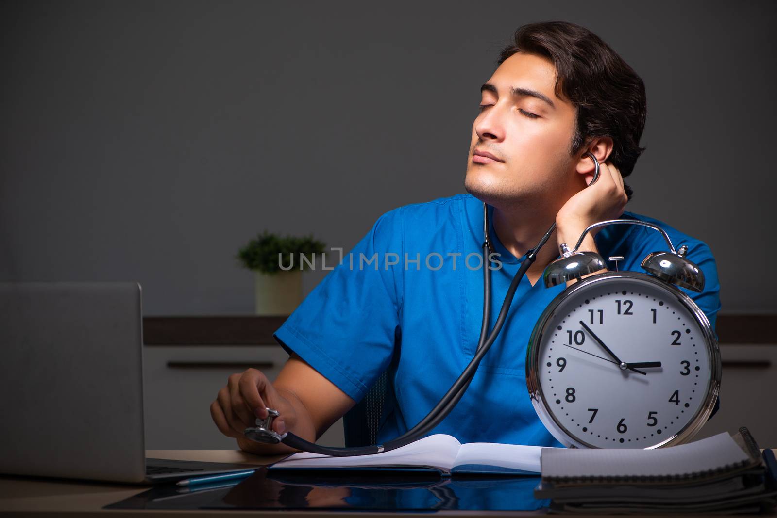 Young handsome doctor working night shift in hospital   