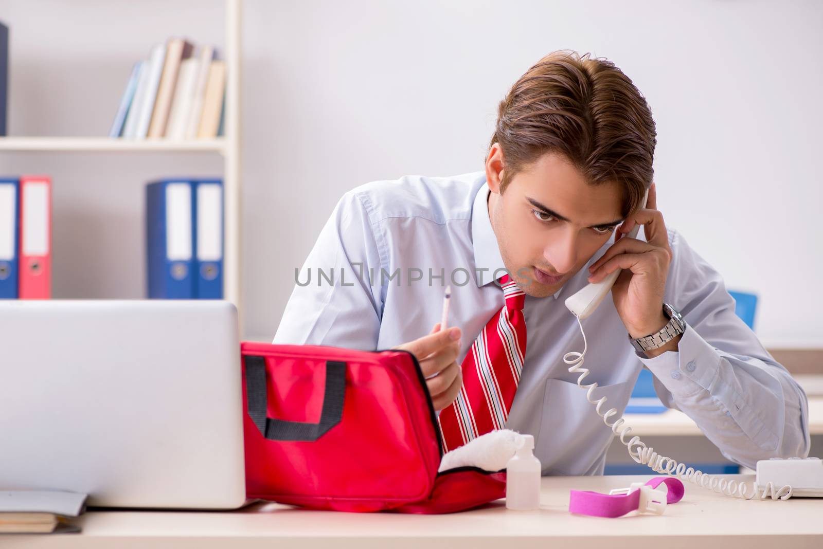 Man with first aid kit in the office