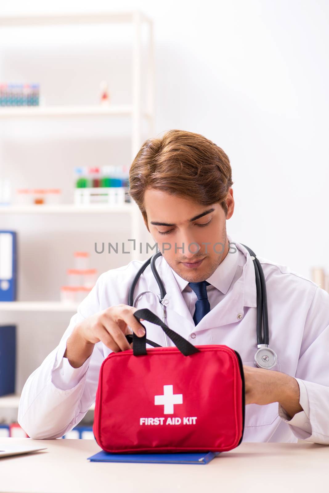 Young doctor with first aid kit in hospital