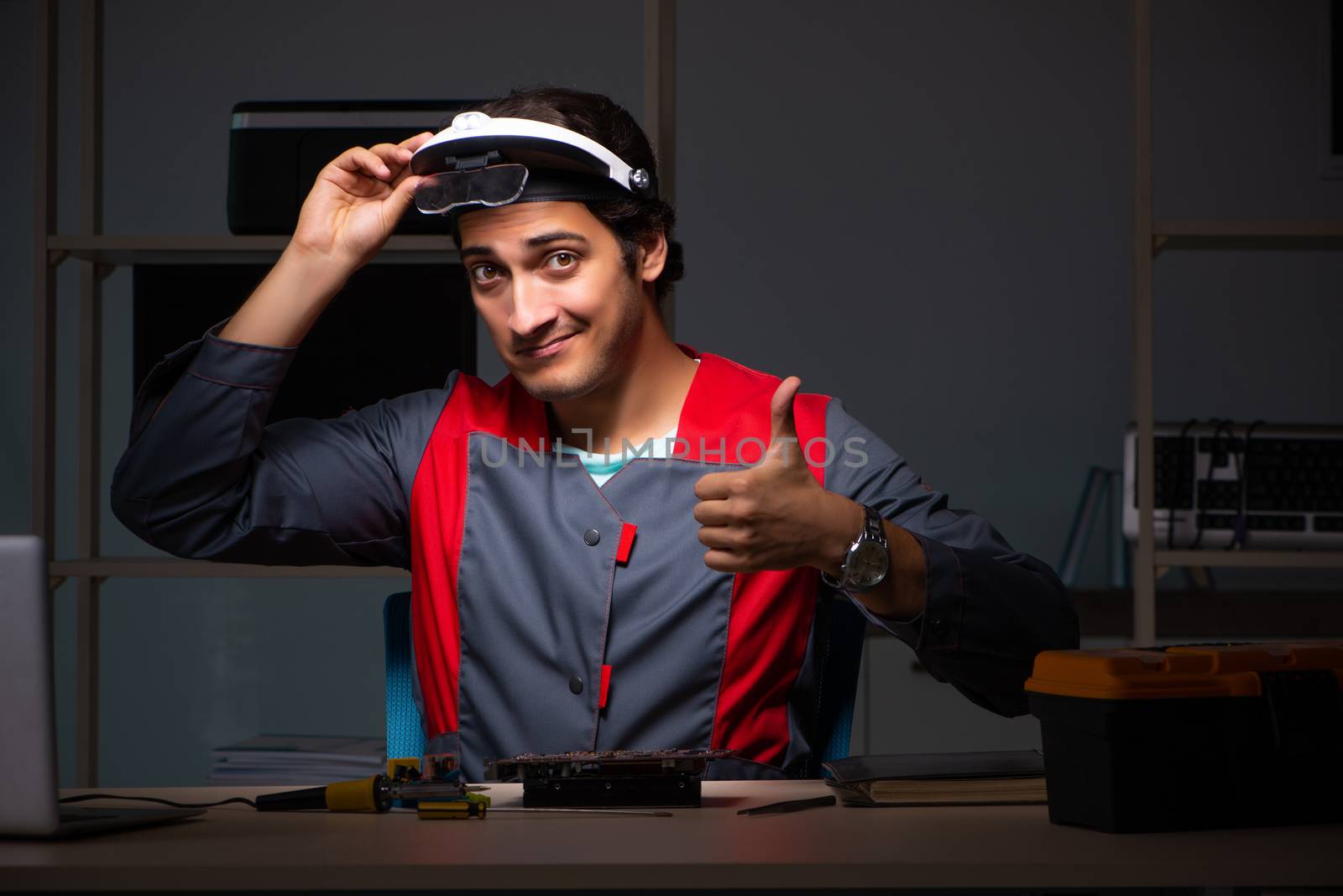 Young handsome repairman repairing computer 